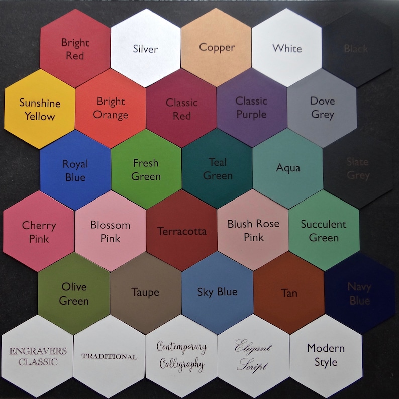 May include: A color chart with 21 hexagonal tiles, each displaying a different color and name. The colors include bright red, silver, copper, white, black, sunshine yellow, bright orange, classic red, classic purple, dove grey, royal blue, fresh green, teal green, aqua, slate grey, cherry pink, blossom pink, terracotta, blush rose pink, succulent green, olive green, taupe, sky blue, tan, and navy blue. The chart also includes text labels for each color, such as "Engravers Classic", "Traditional", "Contemporary Calligraphy", "Elegant Script", and "Modern Style".