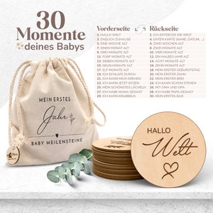 May include: A set of 30 wooden circles with a white canvas bag. The circles are engraved with milestones for a baby's first year, such as "Hello World", "First Tooth", and "First Bath". The bag has the text "My First Year" and "Baby Milestones" printed on it.
