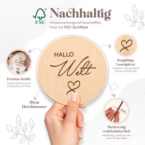 May include: A wooden round sign with the text "Hallo Welt" (Hello World) in cursive script and a heart symbol. The sign is 10 inches in diameter and made from sustainably sourced wood with an FSC certification.