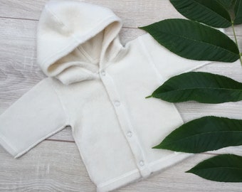 May include: A white hooded sweater with button closures. The sweater is made of a soft, fuzzy material and has a relaxed fit.