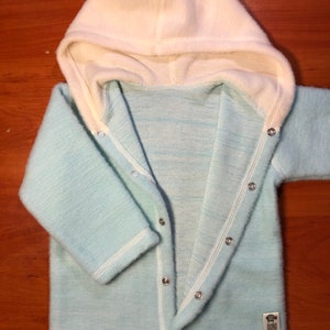 May include: A light blue hooded baby sweater with white trim and a row of silver buttons down the front.