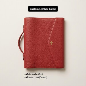 May include: Red leather Bible cover with a camel-colored cross emblem. The cover has a handle and a flap closure. The text "Custom Leather Colors" is at the top, with "Main body (Red)" and "Mosaic cross (Camel)" at the bottom.