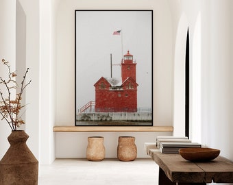May include: A hallway with white walls and arched doorways. A large framed photograph of a red lighthouse with an American flag flying from the top hangs on the wall. A wooden bench with a bowl on top sits in the hallway. A large brown vase with dried branches sits on the floor.