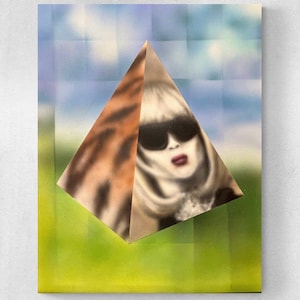 May include: A woman's face is partially obscured by a pyramid-shaped object. The pyramid is made of a brown and white patterned material. The background is a blurred image of a blue sky and green grass.