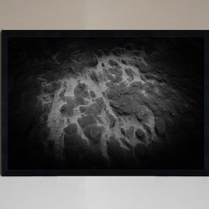 Könnte beinhalten: Schwarzweißfoto einer strukturierten Oberfläche mit einem Muster aus hellen und dunklen Bereichen. Die Oberfläche scheint aus Stein oder Sand zu bestehen.