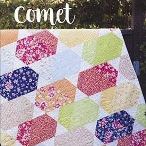 May include: A quilt pattern called "Comet" featuring a geometric design with colorful hexagonal shapes. The quilt is made with a variety of floral fabrics in shades of pink, blue, yellow, and green.