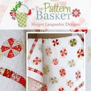 May include: A white quilt with a red and green candy cane pattern. The quilt is folded in half and the edges are trimmed with a red and white ribbon. The quilt is called "Candy Wrappers" and the website is www.thepatternbasket.com.