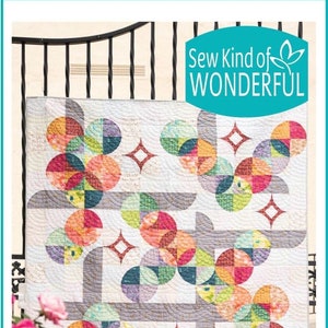 Könnte beinhalten: Ein farbenfrohes Quilt mit einem geometrischen Design aus Kreisen und Quadraten in verschiedenen Farben. Das Quilt hat einen weißen Hintergrund mit grauen Akzenten und den Text "Sew Kind of WONDERFUL" und "Moon Dance Revival".