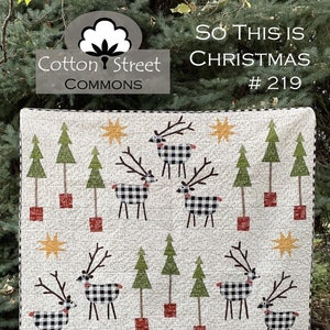 May include: A white quilt featuring a black and white checked reindeer pattern, green trees, and red and yellow stars. The quilt is titled "So This is Christmas #219" and is a Cotton Street Commons design.