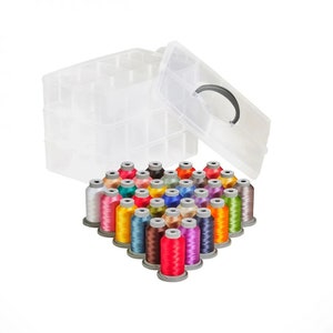 Puede incluir: Una caja de almacenamiento de plástico transparente con asa, que contiene una variedad de carretes de hilo de colores.