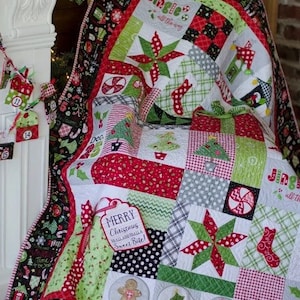 Puede incluir: Un edred&oacute;n con tem&aacute;tica navide&ntilde;a con un dise&ntilde;o de patchwork. El edred&oacute;n presenta telas rojas, verdes, blancas y negras con motivos navide&ntilde;os como estrellas, bastones de caramelo y &aacute;rboles de Navidad. Una etiqueta dice "Merry Christmas to all and halls Sweet Bite!"