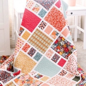 May include: A colorful quilt with a geometric pattern of squares and rectangles in shades of pink, red, yellow, blue, and green. The quilt is made with a variety of fabrics, including floral prints and solid colors. The quilt is titled "Craftsman" and is by Amy Smart, Diary of a Quilter.