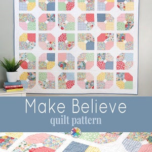 May include: A quilt pattern called "Make Believe" featuring a colorful patchwork design with pink, blue, green, and yellow squares. The quilt is made up of smaller squares with floral patterns. The pattern is available from "a bright corner".