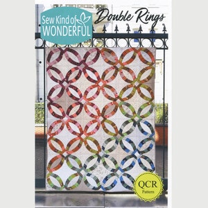 May include: A quilt pattern called "Double Rings" by Sew Kind of Wonderful. The quilt is made up of a series of interlocking rings in shades of red, orange, green, blue, and white.