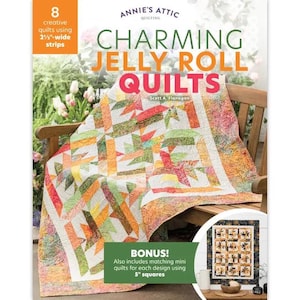 May include: A colorful quilt book cover titled "Charming Jelly Roll Quilts" by Annie's Attic. The cover features a vibrant quilt draped over a wooden bench. The book includes patterns for quilts using 2.5-inch strips and 5-inch squares.