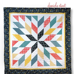 Puede incluir: Un patrón de acolchado con una gran estrella hecha de triángulos de medio cuadrado en tonos de azul, amarillo, rojo y blanco. El acolchado está rodeado por un borde negro con un patrón floral blanco. El texto "giant star" y "half-square triangles with ease" se muestra sobre el acolchado. El texto "daniela stout" se muestra debajo del acolchado. El texto "Cozy Quilt Designs®" se muestra debajo del acolchado. El texto "Great with The Strip Tube Ruler!" se muestra en un círculo debajo del acolchado.