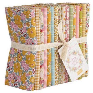 May include: A stack of fabric bundles tied with a cream ribbon. The fabrics feature floral and patterned designs in yellow, pink, blue, and green. A tag with floral illustrations is attached to the ribbon.