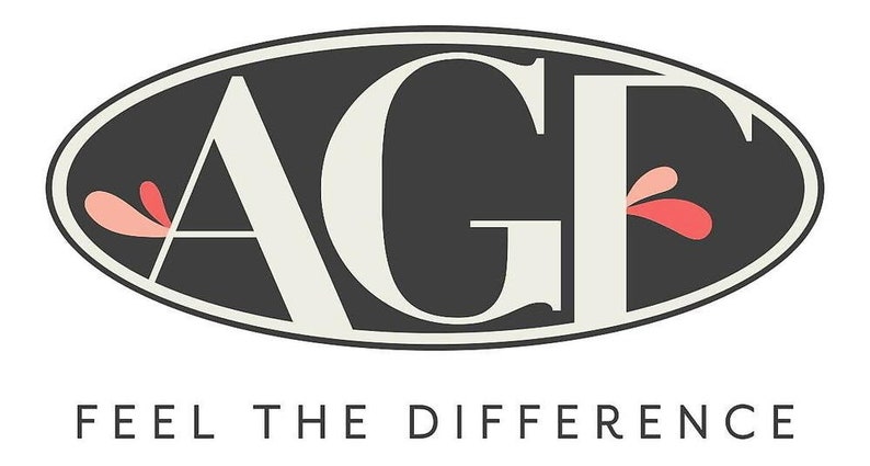 May include: Logo with the letters "AGF" in a cream color, set against a dark gray oval background. The text "FEEL THE DIFFERENCE" is below the logo in a simple, sans-serif font. Pink and red floral accents are on the left and right of the letters.