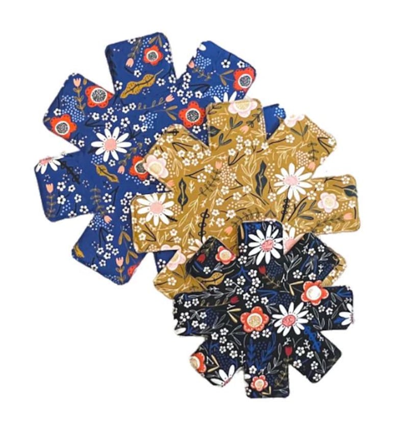May include: Three floral print pot holders in blue, yellow, and black. Each pot holder is shaped like a star with eight points.