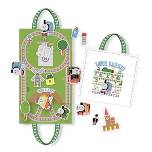 May include: A green and white Thomas the Tank Engine themed playset with a track layout, train cutouts, and a tote bag. The tote bag and playset have green handles. The playset features a helicopter, windmill, and other scenery. The tote bag has the words "Sodor Railway".
