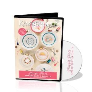 May include: A DVD case with a white disc inside. The case features a colourful image of four embroidered bowls with different designs and text, including "Sewing Space Happy Place" and "Hello Sunshine". The text "Happy Place Embroidery Projects for Machine Embroidery" is also featured on the case.