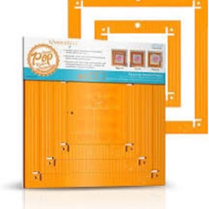 May include: A set of two orange plastic quilting rulers with grid lines and measurements in inches. The rulers are designed for creating square and rectangular frames.