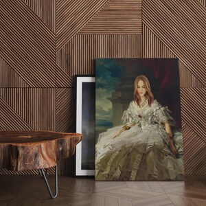Pu&ograve; includere: Una grande stampa su tela di un ritratto di una donna in un abito bianco con una gonna a balze. Il ritratto &egrave; appoggiato a una parete di legno con un motivo geometrico. Un'immagine con cornice nera e un tavolo di legno sono anche nell'immagine.