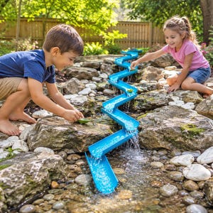 Può includere: Un giocattolo scivolo d'acqua in plastica blu serpeggia lungo un ruscello roccioso. Due bambini giocano con il giocattolo, versando acqua e piccoli oggetti sullo scivolo. L'acqua scorre lungo lo scivolo.