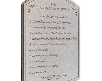 May include: A rectangular plaque with a curved top, featuring the text "THE 10 COMMANDMENTS." The text is in a serif font, with decorative floral accents. The commandments are listed below the title, in a simple, easy-to-read format.