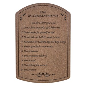 May include: A brown plaque with rounded top edges, inscribed with "THE 10 COMMANDMENTS." The text of the Ten Commandments is listed below the title. Decorative floral accents are at the top and bottom.