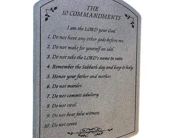 May include: A gray stone plaque with the text "THE 10 COMMANDMENTS" and the Ten Commandments listed below. The plaque has a curved top and decorative floral accents.