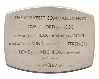 May include: A beige, rectangular plaque with rounded corners. The text reads "THE GREATEST COMMANDMENTS" followed by a quote from Mark 12:30-31. Decorative scrollwork is at the bottom. The plaque is suitable for home decor.