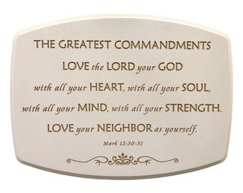 May include: Cream-colored plaque with rounded edges, featuring the text "THE GREATEST COMMANDMENTS" and a quote from Mark 12:30-31. The text is in a dark brown font, with decorative flourishes at the bottom.