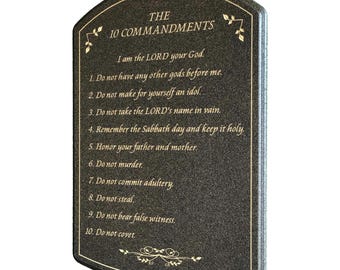 May include: A dark gray plaque with the text "THE 10 COMMANDMENTS" and the Ten Commandments listed below. The text is in gold, with decorative gold accents at the top and bottom. The plaque has a curved top.
