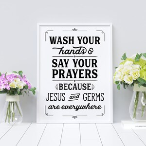 May include: A white framed print with black text that reads "Wash your hands & say your prayers because Jesus and germs are everywhere".
