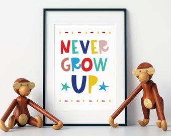 May include: A framed print with the text "NEVER GROW UP" in colorful letters with stars on either side of the word "UP". Two wooden monkey figurines are on either side of the frame.