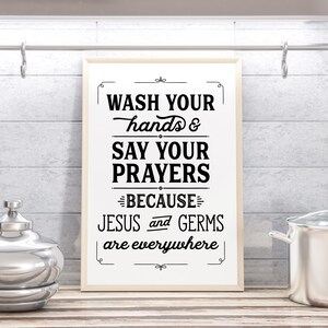 May include: A white framed sign with black text that reads "Wash your hands & say your prayers because Jesus and germs are everywhere".