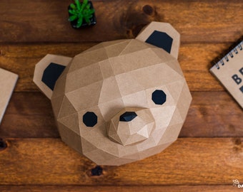 May include: A brown paper bear head sculpture with black eyes and nose. The sculpture is made of folded paper and has a geometric design.