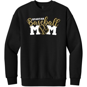May include: Black sweatshirt with gold glitter text that reads "SPARTAN Baseball MOM". The baseball graphic has a heart in the center. The sweatshirt is a crew neck style.