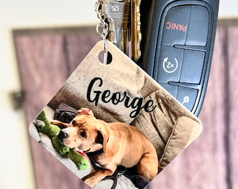 Könnte beinhalten: Ein quadratischer Schlüsselanhänger mit einem Foto eines braunen Hundes mit einem grünen Spielzeug. Der Schlüsselanhänger trägt den Namen "George" in schwarzer Kursivschrift.