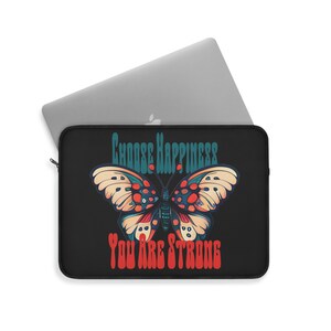 May include: Black laptop sleeve with a colorful butterfly design and the text "Choose Happiness You Are Strong".