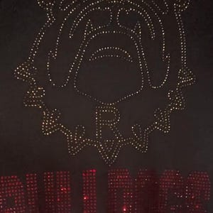 May include: Black t-shirt with a gold rhinestone bulldog design and the word "BULLDOGS" in red rhinestones.