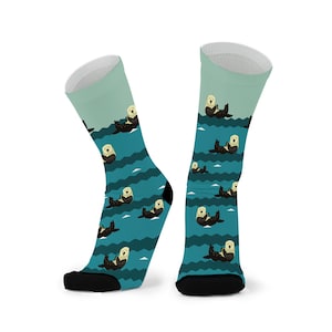 May include: A pair of blue and green socks with a pattern of sea otters swimming in the ocean waves.