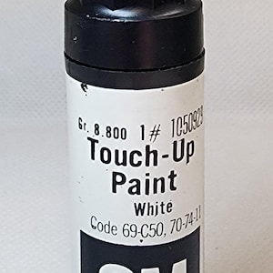 May include: White touch-up paint in a cylindrical bottle with a black cap and orange top. The label reads "Touch-Up Paint White" and includes the GM logo. Net contents: 1/2 fl oz.