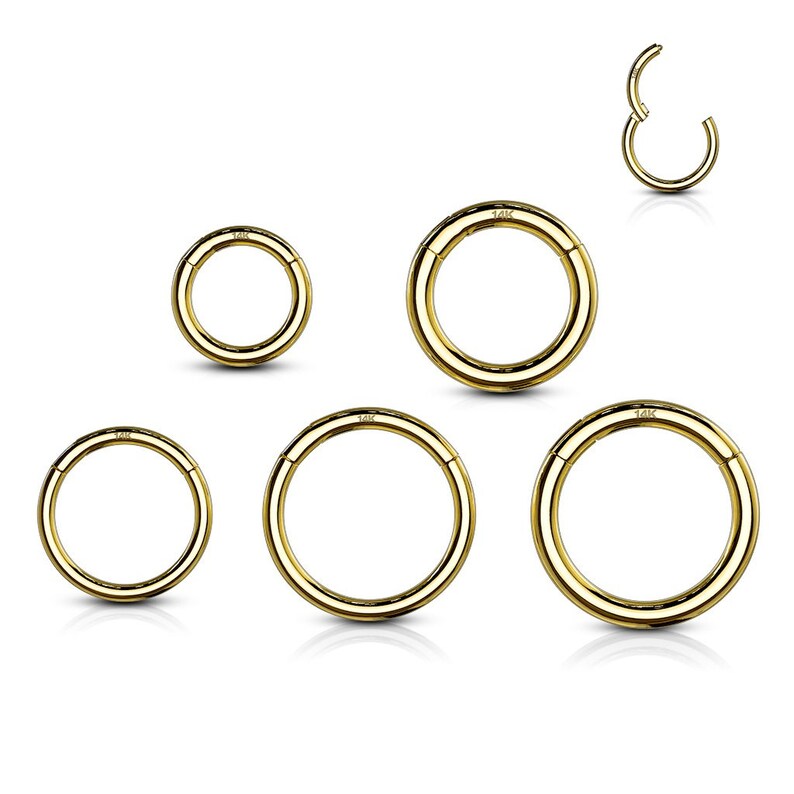 May include: A collection of six polished gold-tone hinged segment rings of varying diameters. Each circular ring features a smooth, seamless design with a small hinge mechanism and the text 14K stamped clearly on the metal surface.
