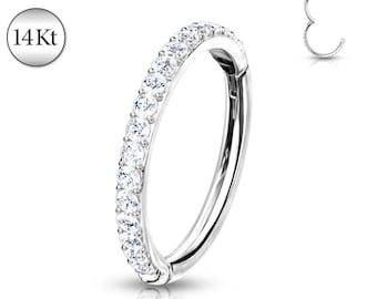 May include: A silver-colored hinged ring earring with a row of clear, sparkling stones. The earring is shown in two views, with the text "14Kt" in a circular frame. The jewelry is set against a white background.