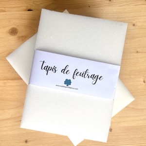 Puede incluir: Hoja de tela de fieltro blanco con una etiqueta que dice "Tapis de feutrage" y "www.mylittlepretendfabrics.com".