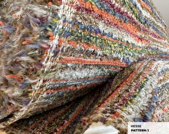 May include: Close-up of a multi-colored woven fabric with a fuzzy texture. The fabric has stripes of orange, brown, white, green, and blue. The fabric is labeled "HESSE PATTERN: 1".