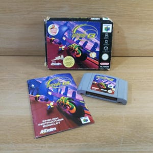 May include: A Nintendo 64 video game set including the Extreme-G game cartridge, the original cardboard box with purple and orange graphics, and the English instruction booklet. The box features the Acclaim logo and Nintendo 64 branding.