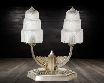 Lampe ART DECO en bronze argenté composé de deux bras type chandelier, surplombés d'abats jour en verre moulé pressé dépoli